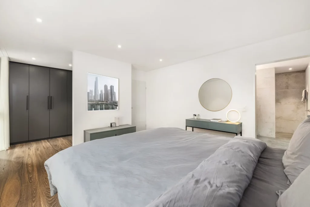 Modernes Elternzimmer mit klaren Linien, hellen Wandflächen, Einbauschrank, direktem Badzugang und ruhiger, aufgeräumter Atmosphäre.
