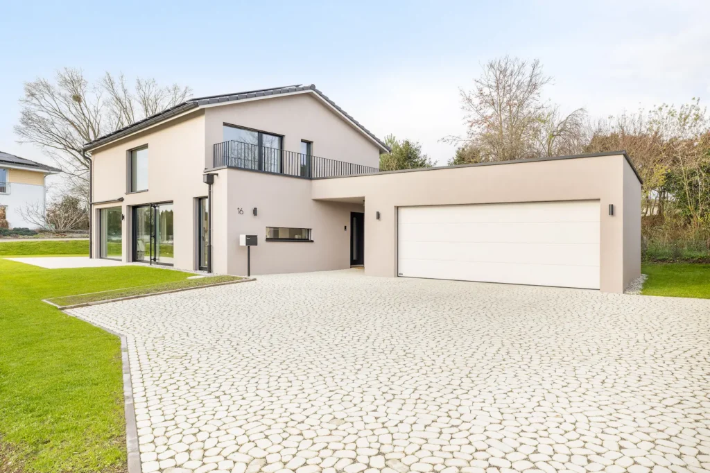 Grosszügiger Vorplatz mit Pflästerung vor modernem Einfamilienhaus mit angebauter Garage