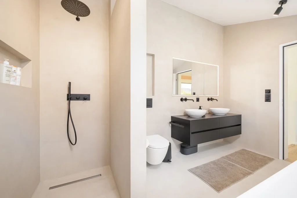 Modernes Badezimmer mit offener Dusche, Doppelwaschbecken, Spiegel und klarer Farbgestaltung.