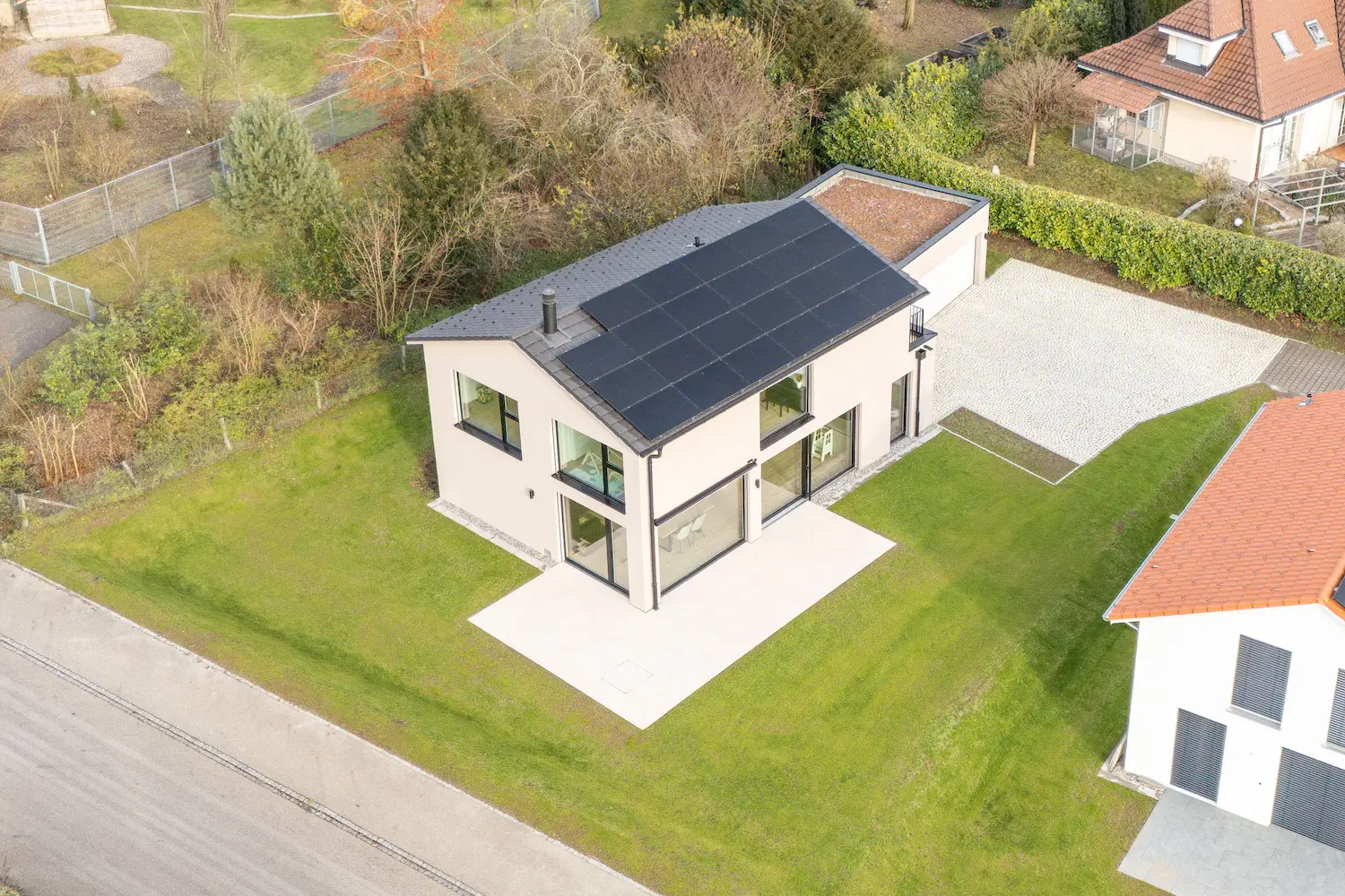 Vogelperspektive von individuell geplantesm Einfamilienhaus mit Satteldach, Photovoltaik, grosszügiger Terrasse und offenem Wohnbereich zum Garten.