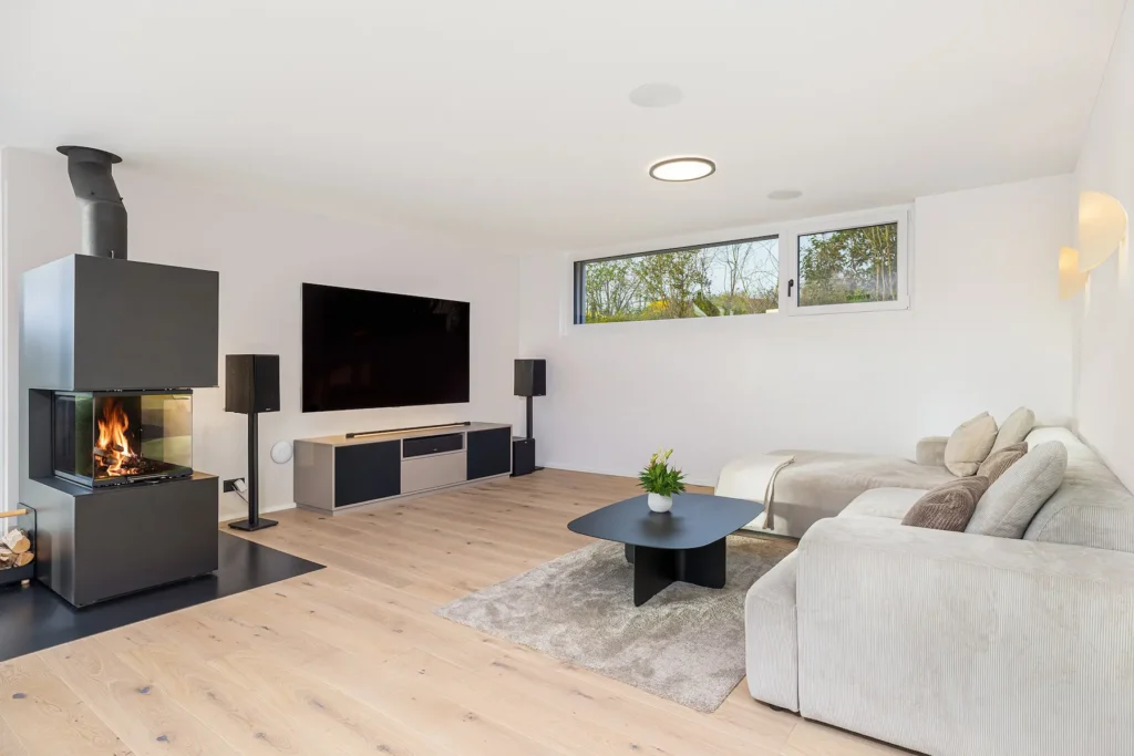 Heller Wohnraum mit Kamin, gemütlicher Sofaecke und ruhiger, moderner Gestaltung.