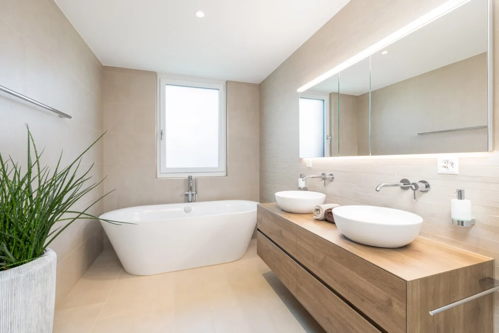 Modernes Badezimmer mit freistehender Badewanne und Doppelwaschbecken auf Holzwaschtisch.