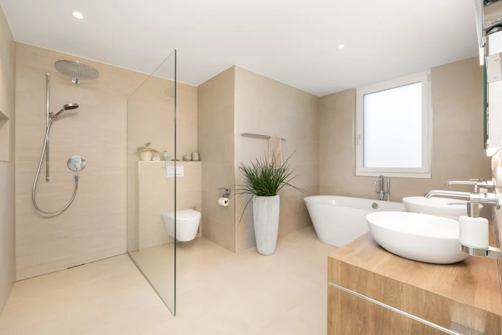Großzügiges Masterbad mit bodengleicher Dusche, freistehender Badewanne und Doppelwaschbecken