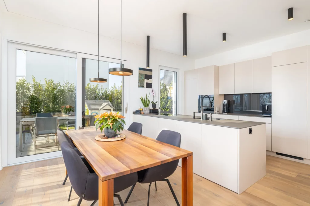 Offene Küche mit Esstisch und Zugang zur Terrasse.