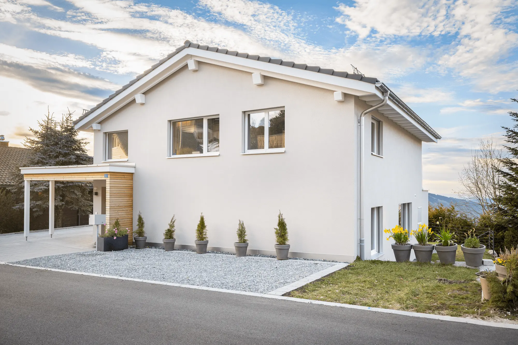 Individuell geplantes Einfamilienhaus mit Satteldach, klarer Fassadengestaltung und Holzdetails im Eingangsbereich.