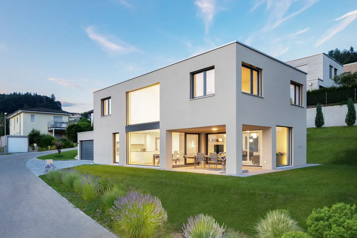 Modernes Einfamilienhaus mit heller, graue-beiger Fassade, klarer Kubatur, vielen Fenstern , Galerie nd gepflegtem Garten in ruhiger Wohnlage.