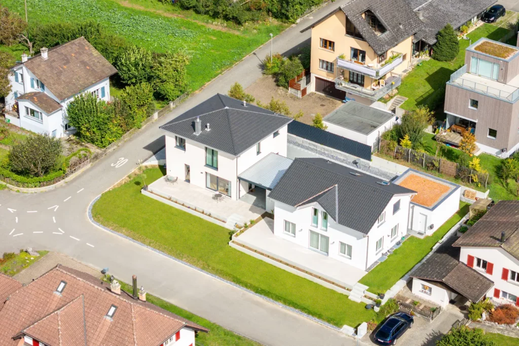 Luftaufnahme eines freistehenden Einfamilienhauses mit Garten und Terrasse in einem gewachsenen Wohngebiet.