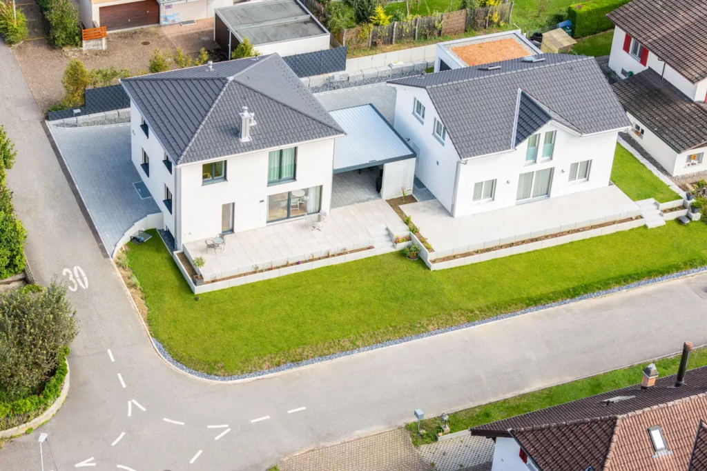 Zwei moderne Atmoshaus-Einfamilienhäuser mit großzügigen Terrassen und gepflegten Gärten in familienfreundlicher Wohnlage.